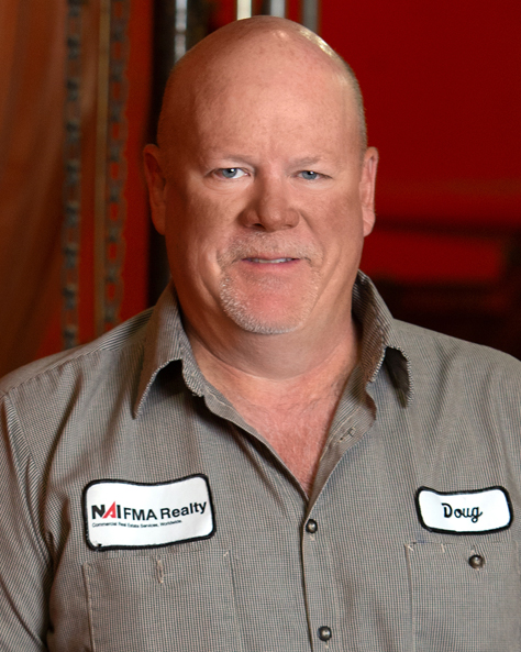 Portrait of Doug Meier, Maintenance Supervisor at NAI FMA Realty, standing in an industrial facility.