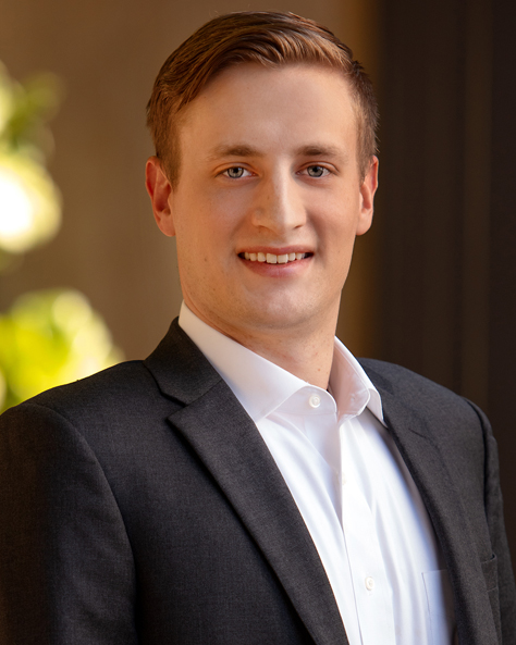 Portrait of Dayton Stange, Property Manager at NAI FMA Realty, standing in an office setting.