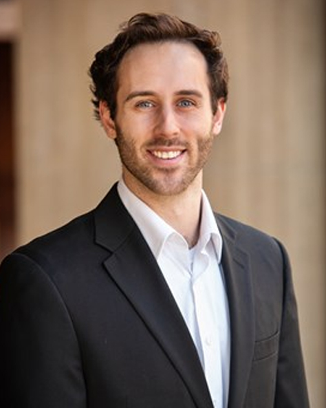 Portrait of Jared Froehlich, Commercial Advisor at NAI FMA Realty, smiling in a professional office setting.