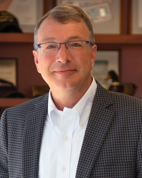Portrait of Tom Graf, CCIM, Commercial Advisor at NAI FMA Realty, standing in an office setting.